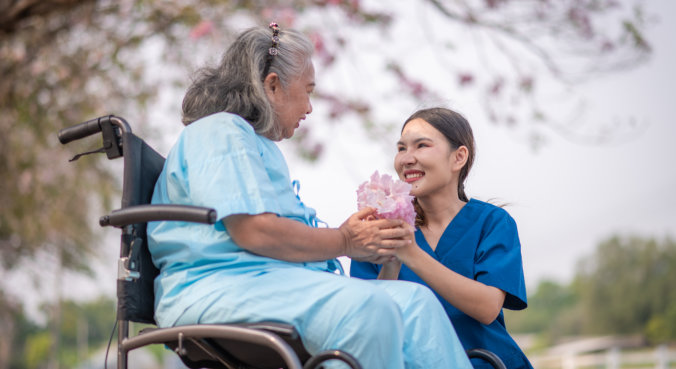 caregiver giving flower to elderly